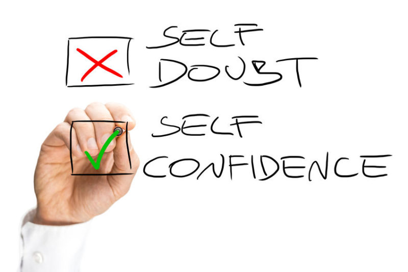Self Doubt and Confidence Check Box List Human Hand Marking X on Self Doubt and Check on Self Confidence in Check Box List. Isolated on White Background.